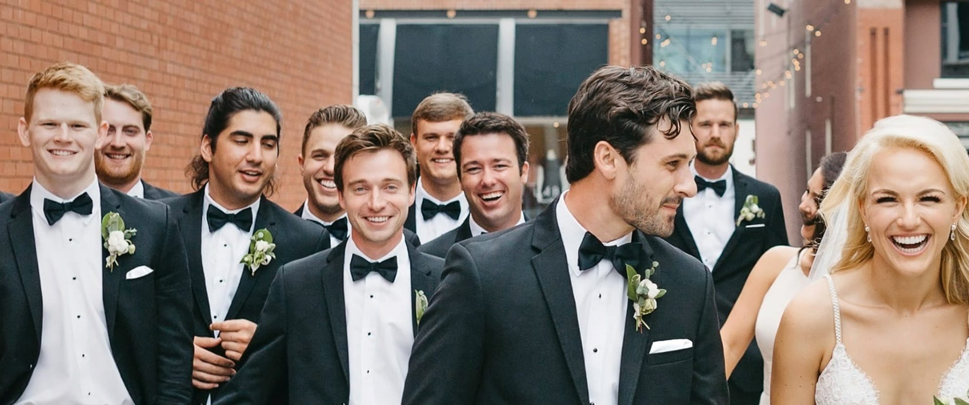 Mainline Custom Clothiers Formalwear - Wedding scene, bride and groom with groomsmen.